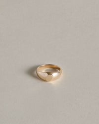 Gold oval signet ring on a light gray background