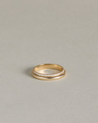 Gold ring with an eternity band of pave diamonds on a light gray background